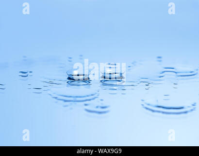 Contact lenses for the eyes on the glass among the drops of water in blue. Optical equipment, good vision, optometrist. Stock Photo