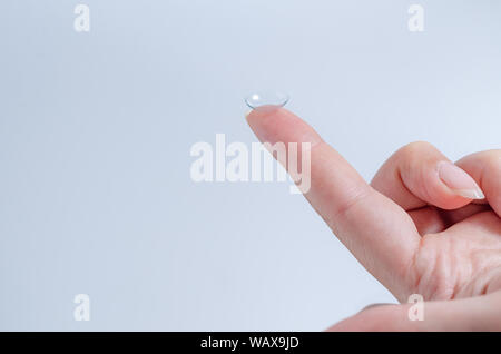Contact lens close-up on a woman’s fingertip. Good vision, optometrist, treatment. Stock Photo