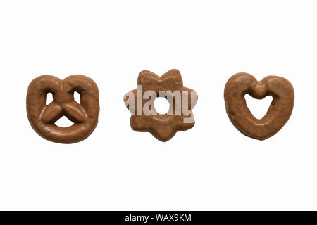 Chocolate glazed gingerbread cookies isolated on white background. Chocolate pastry in the different shape and feelings top view. Stock Photo