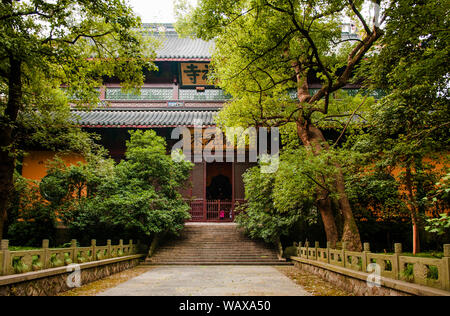 AUG 17, 2011 Hangzhou, China : Grand red wooden prayer hall of ancient Lingyin temple Buddhist monastery among big tree, sacred place for monks use fo Stock Photo