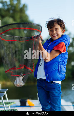 Little boy holding up fish he caught in a pond Stock Photo - Alamy