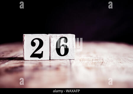Number 26 isolated on dark background- 3D number twenty six isolated on vintage wooden table Stock Photo