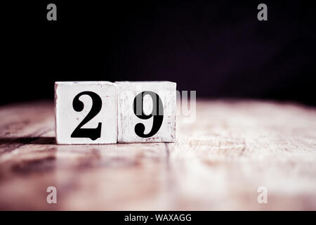 Number 29 isolated on dark background- 3D number twenty nine isolated on vintage wooden table Stock Photo