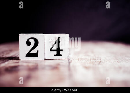 Number 24 isolated on dark background- 3D number twenty four isolated on vintage wooden table Stock Photo