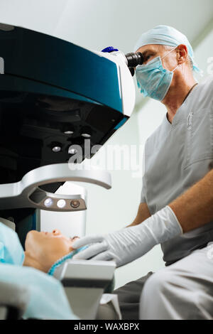 Nice professional doctor sitting near the patient Stock Photo