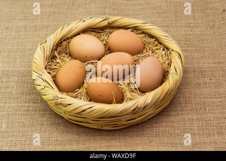 fresh organic chicken eggs laid on the basket with straw Stock Photo