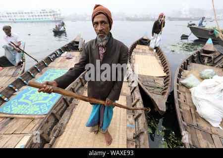 Bangladeshi boatsmen navigate their traditional boats on Buriganga River near Sadarghat in Dhaka, Bangladesh Stock Photo
