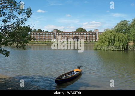 the 1930s art deco apartment block of thames eyot, twickenham, middlesex, england, seen from across the river thames with small boat in foreground Stock Photo