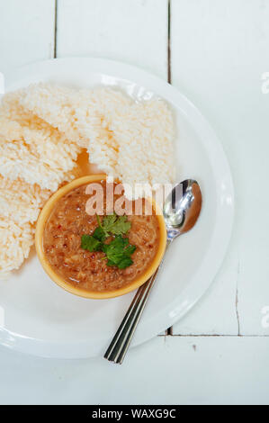 Thai crispy rice cake with shrimp tammarind peanut sauce - Thai traditional snack in white plate on white table. Top view shot Stock Photo