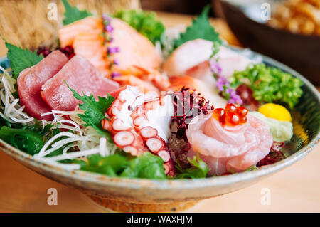 Assorted fresh Japanese Otoro tuna sashimi, Otoro, Tako, Salmon, Hamachi and wasabi in craft ceramic bowl, close up shot Stock Photo