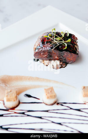 Fried Foie gras with sweet and sour balsamic sauce, pear sauce and cookie Stock Photo