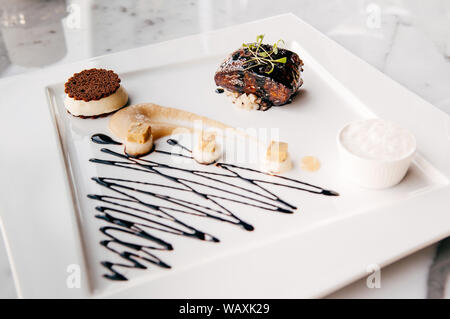 Fried Foie gras with sweet and sour balsamic sauce, pear sauce and cookie Stock Photo