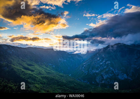 Montenegro, Spectacular sunset sky with glowing red clouds and blue sky decorating majestic gorge of famous tara river canyon nature landscape in durm Stock Photo