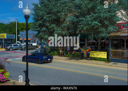 Bryson, North Carolina, USA - August 3, 2019:  People wave from the sidewalk as the train travels through the town of Bryson. Stock Photo