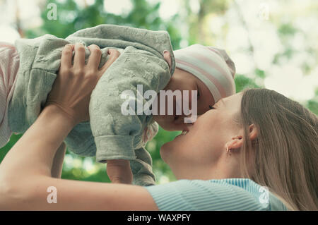 Mom walks with the baby in the park. The baby in her arms. Spring Stock Photo