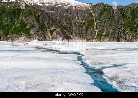 closeup of the surface of the mendenhall glacier near juneau alaska with the canyon wall in the background Stock Photo