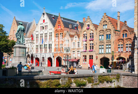 The Jan van Eyckplein (Jan van eyck square) Flanders, with medieval houses and sightseeing tourists on a sunny day. Bruges, Belgium. Stock Photo