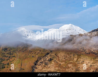 The summits of Mount Snowdon left and Crib Goch right wreathed in mist Snowdonia National park North Wales UK March 7647 Stock Photo