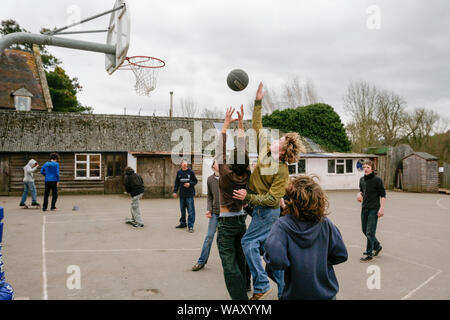 Pupils playing basketball in the playground at the Waldorf Steiner School in Hereford, UK Stock Photo