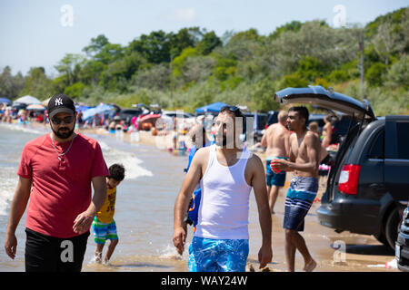 Two Men Walking At Nickel Beach, Port Colborne, Ontario While Crowds Of People Having Fun In The Background Stock Photo