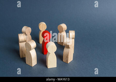 Red human figure surrounded by a circle of people. Leader Boss and leadership. Cooperation and teamwork. Outcast, hated opponent, criminal. Conviction Stock Photo