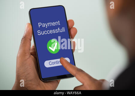 Close-up Of Person's Hand Showing Payment Successful Message On Mobilephone Screen Stock Photo