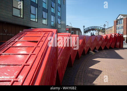 12 telephone boxes toppled over like dominoes is symbolic of Kingston Upon Thames, Surrey. Out of Order, by David Mach, arrived in 1989. Stock Photo