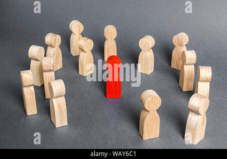 Red human figure surrounded by a group of people. Leader Boss and leadership. Cooperation and teamwork. Outcast, hated opponent, criminal. Conviction. Stock Photo