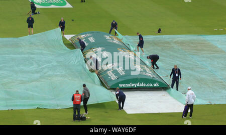 LEEDS, ENGLAND. 22 AUGUST 2019: Ground staff put the rain covers on before start of play day one of the 3rd Specsavers Ashes Test Match, at Headingley Cricket Ground, Leeds, England. Stock Photo