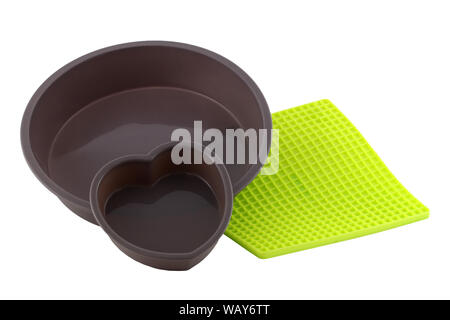 Set of Silicone molds for baking isolated on white background. There's a corpus baking mold and a heart-shaped mold. Silicone pad for hot pot. You can Stock Photo
