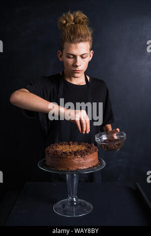 Young and curvy chef decorating chocolate cake Stock Photo