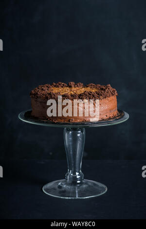Chocolate cake on a stand in front of dark background Stock Photo
