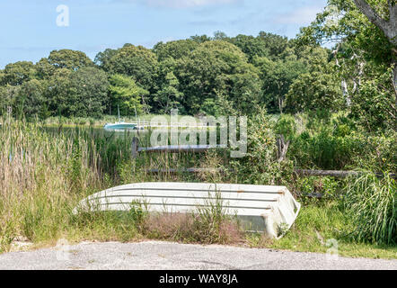 old flat bottom boat upside down in the weeds Stock Photo