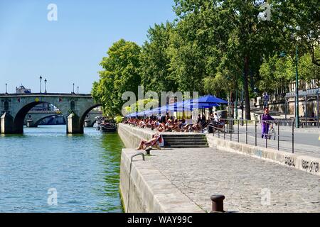 People relaxing in the Paris Plage area along the Seine River during the warm days of August, Paris, France. Stock Photo