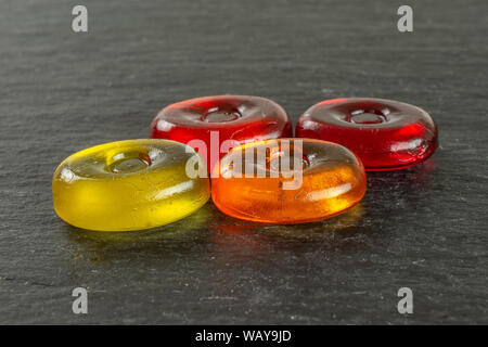 Group of four whole colourful hard candy on grey stone Stock Photo