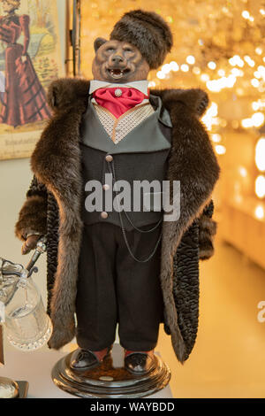 Bear in a fur coat stands on his feet in red clothes. Mannequin tall and handsome. Stock Photo