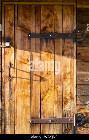 Old wooden doors closed on padlocks. Doors with forged metal elements. Grunge texture Stock Photo