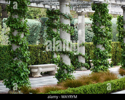 MADRID, SPAIN - APRIL 23, 2018: Pillars of pergola and bench surrounded by plants in the Gardens of Cecilio Rodriguez of the Retiro Park, Madrid, Spai Stock Photo