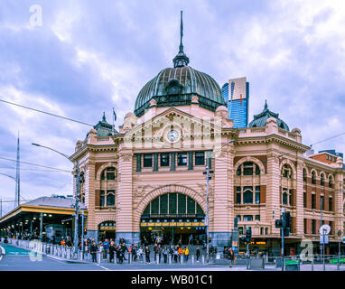 Melbourne, Australia - July 28, 2019: People waiting to cross busy street near Flinders Street Station main entrance Stock Photo