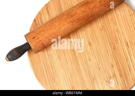 A wooden rolling pin on a bamboo cutting board isolated on white Stock Photo
