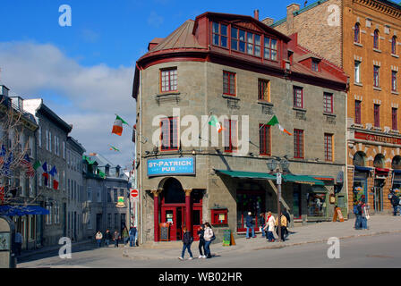 Quebec City, Canada - April 10, 2009:  People walking on Rue Saint-Jean in old Quebec City with its historic buildings including St-Patrick Pub and Ch Stock Photo