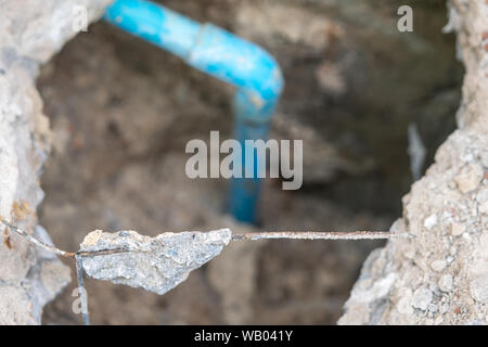 leaking water from blue pipe from underground Stock Photo