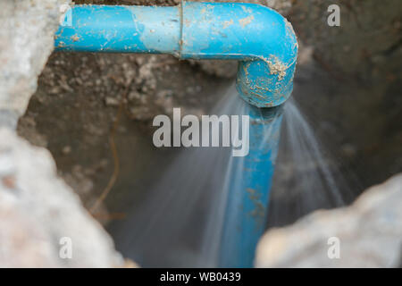 leaking water from blue pipe from underground Stock Photo