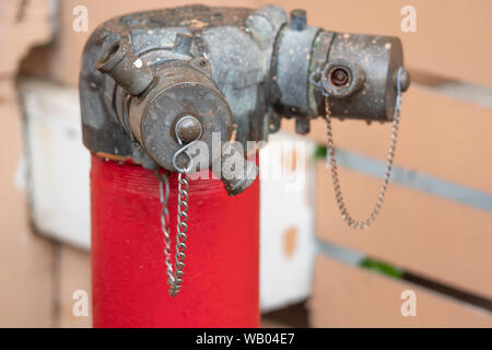 Red fire hydrant water pipe with a chain on the street Stock Photo