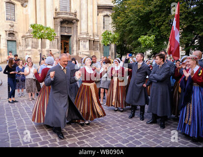 Latvian Folklore group in traditional costumes dancers performing number during Parade of Etnovyr Festival in street of Lviv. Lviv, Ukraine Stock Photo