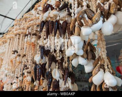 Traditional colorful home decorations made from different shape and color seashells. Souvenir hangings on the tropical sea resort market Stock Photo