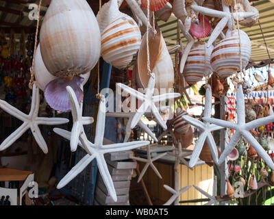 Traditional colorful home decorations made from different shape and color seashells. Souvenir hangings on the tropical sea resort market Stock Photo