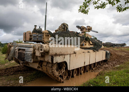 An M1 Abrams Tank belonging to the 3rd Battalion, 66th Armored Regiment secures an objective against Opposing Forces (OPFOR) during the culminating force on force exercise at Combined Resolve XII in Hohenfels Training Area, Germany Aug. 19, 2019. Combined Resolve is a biannual U.S. Army Europe and 7th Army Training Command-led exercise intended to evaluate and certify the readiness and interoperability of US forces mobilized to Europe in support of Atlantic Resolve. (U.S. Army photo by Sgt. Jeremiah Woods) Stock Photo