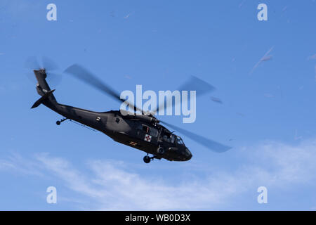 A U.S. Army UH-60L Black Hawk ascends for takeoff after the completion of a training scenario where U.S. Air Force emergency managers and U.S. Army CBRN specialists and medics perform aircraft and patient decontamination after a simulated attack, while Army medics provide evacuation and treatment of role players during integrated training as part of exercise Patriot Warrior at Fort McCoy, Wis., Aug. 20, 2019. Patriot Warrior is Air Force Reserve Command's premier exercise providing Airmen an opportunity to train with joint and international partners in airlift, aeromedical evacuation, and mobi Stock Photo