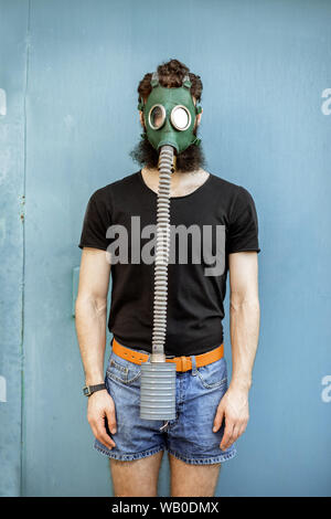 Portrait of a man with gas mask on the blue background. Concept of poor ecology, air pollution and radiation hazards Stock Photo